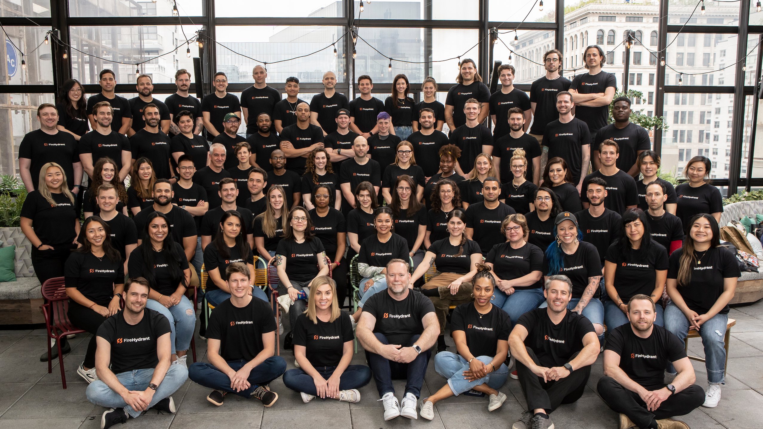 A group photo of the FireHydrant team in branded t-shirts. 