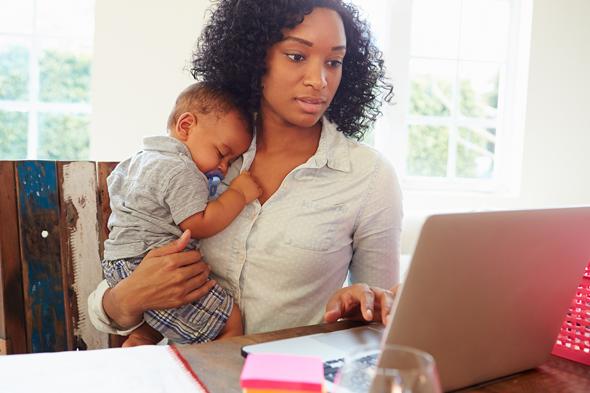 Mother With Baby Working In Office At Home