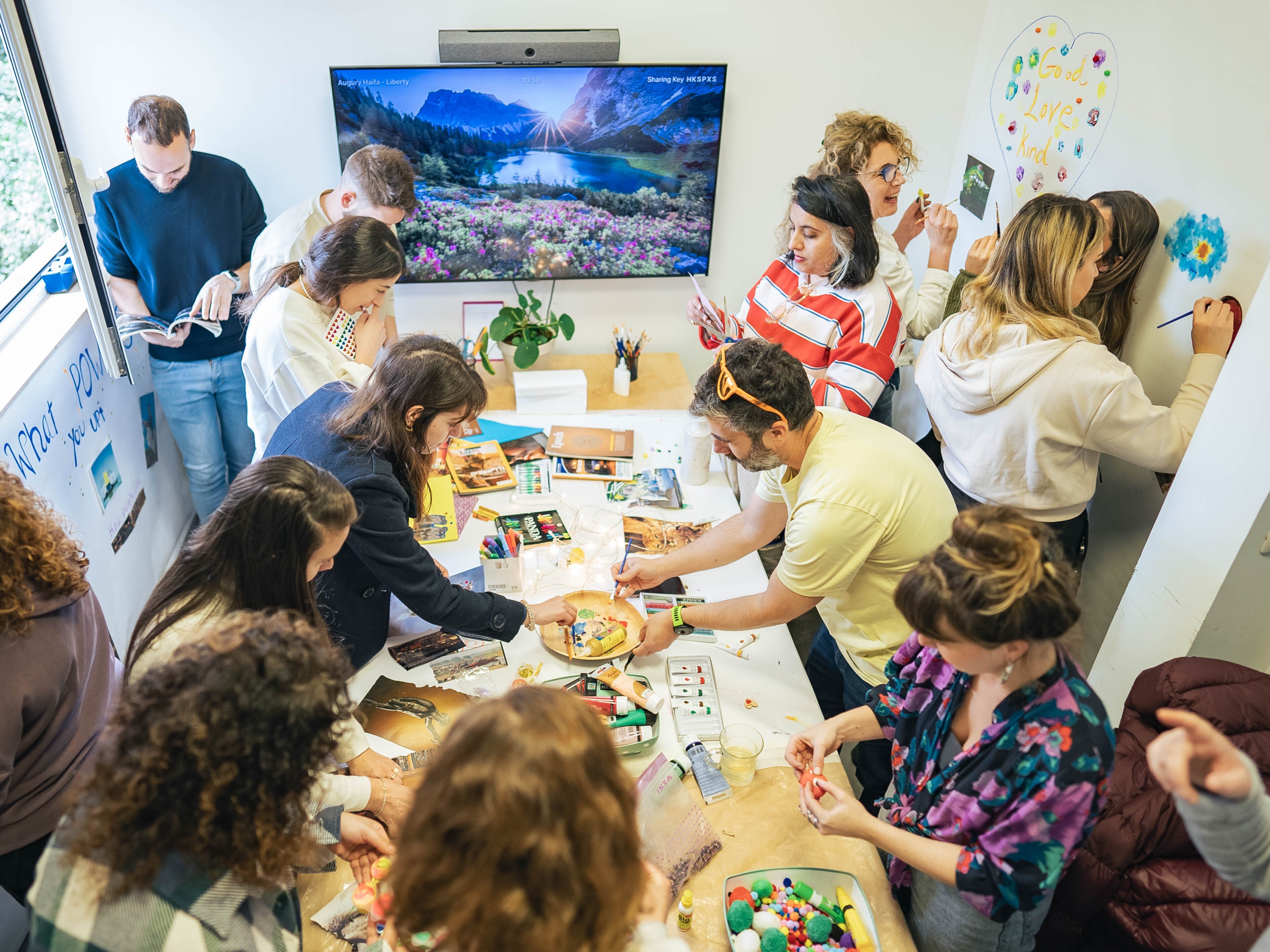 Augury team members do arts and crafts together in an office meeting room. 