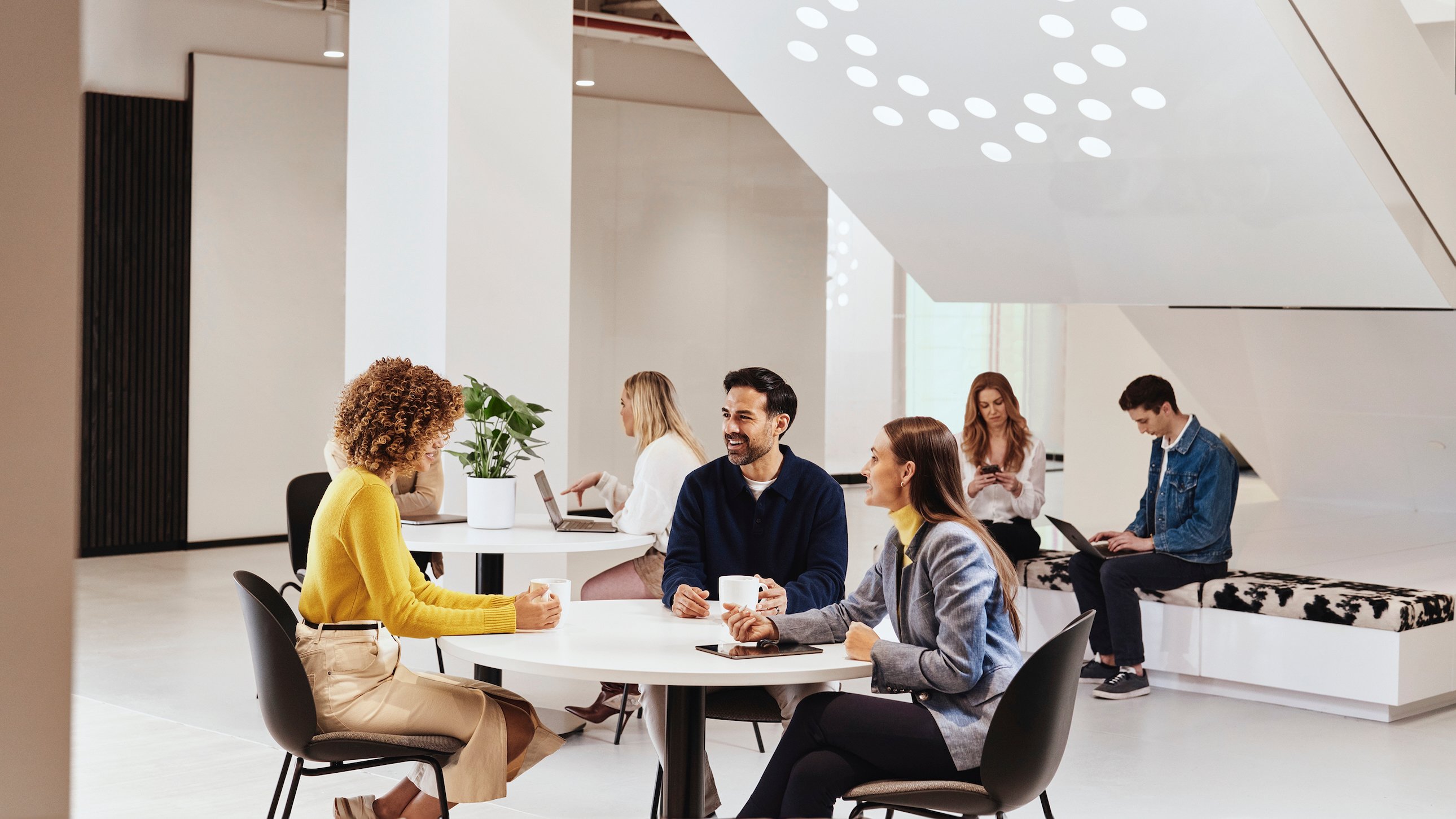 CLEAR employees meet at a round table in a common area of the office