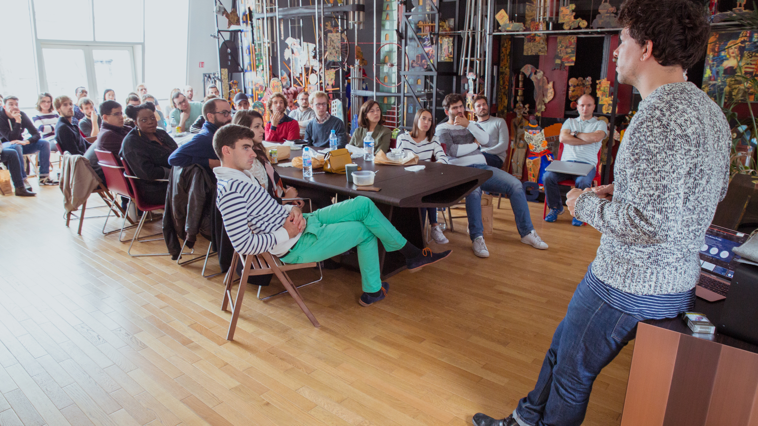 360Learning employees listen to a colleague present. 