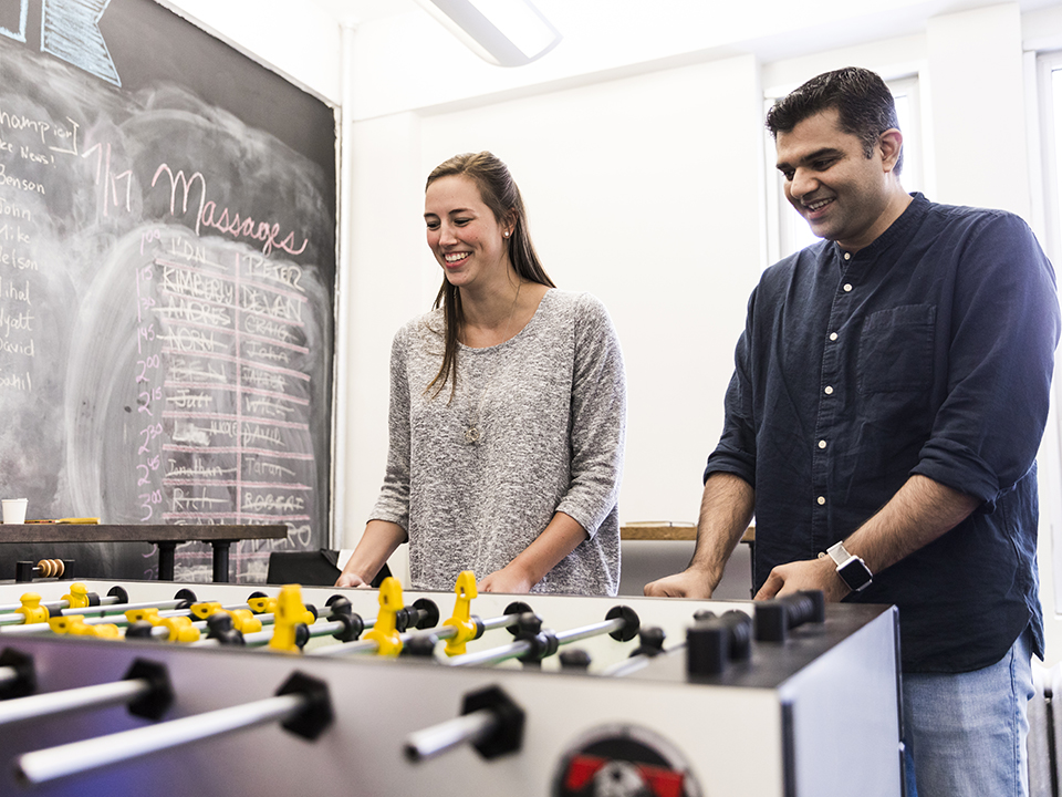 Kimberly and Vandan playing foosball in the office