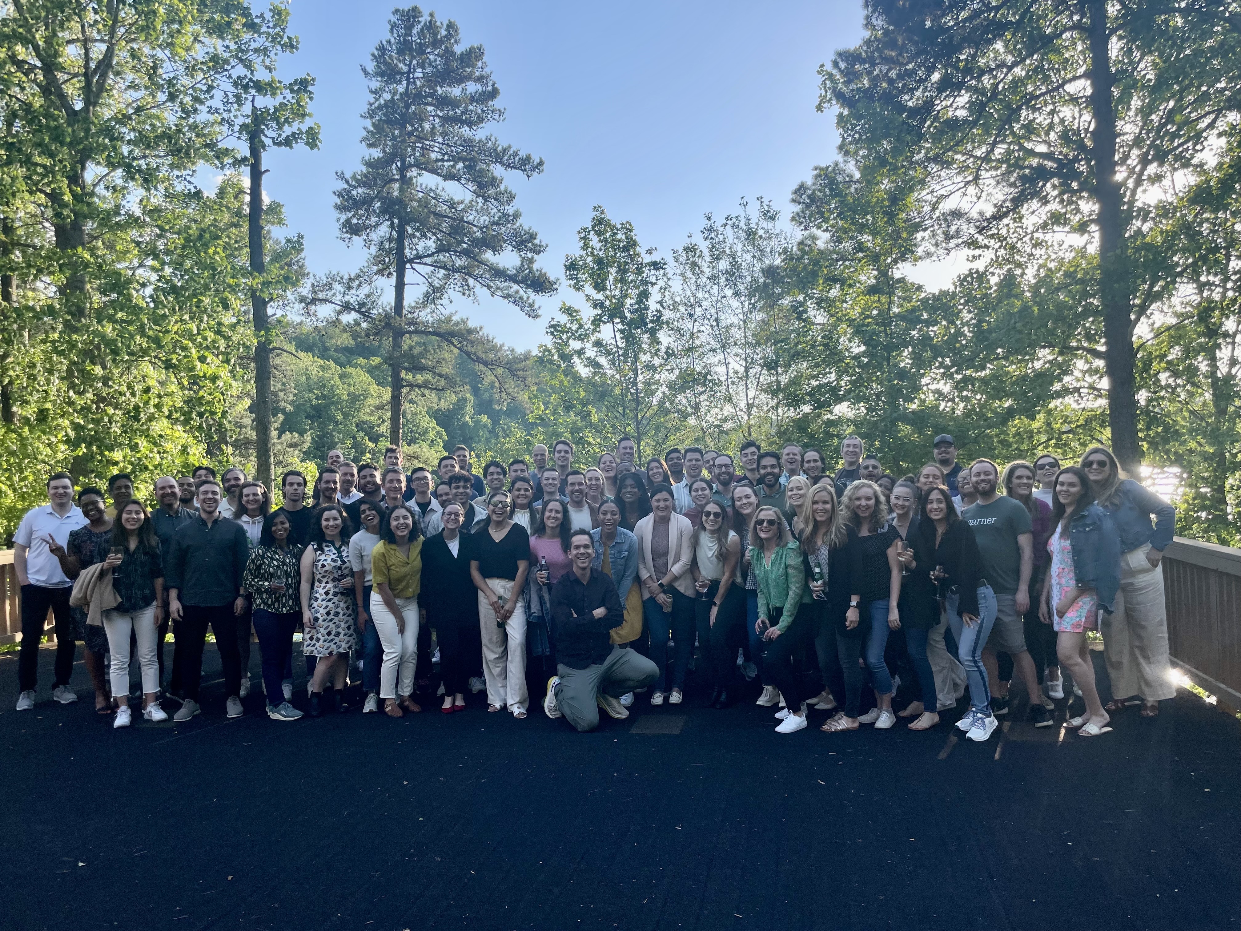 Outdoor large group photo of Garner Health team with trees and blue sky in the background.