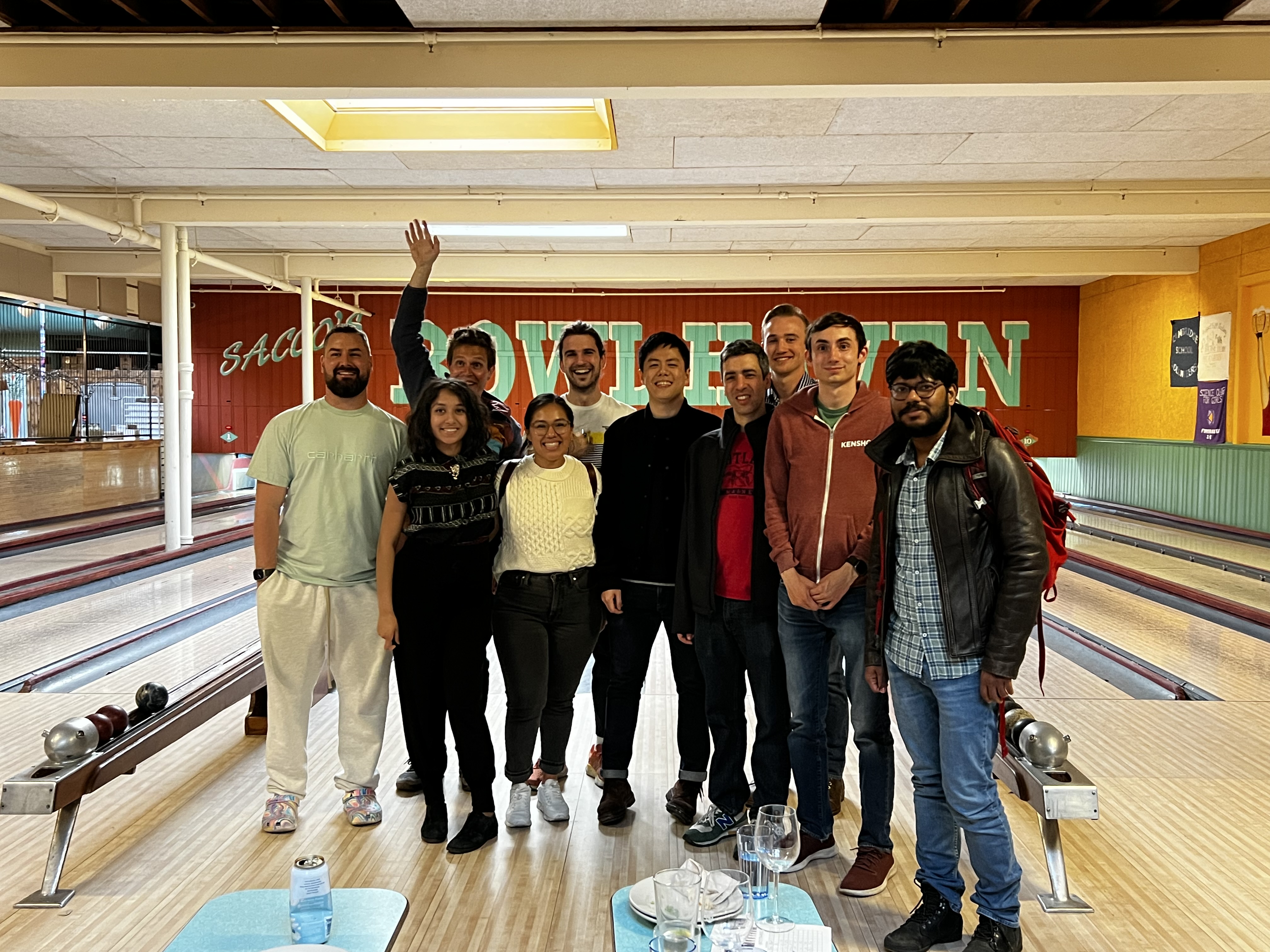 A team from Kensho takes a moment to pose for a group photo during a celebration at a bowling alley. The group was able to launch an MVP of ChatIQ within eight weeks.