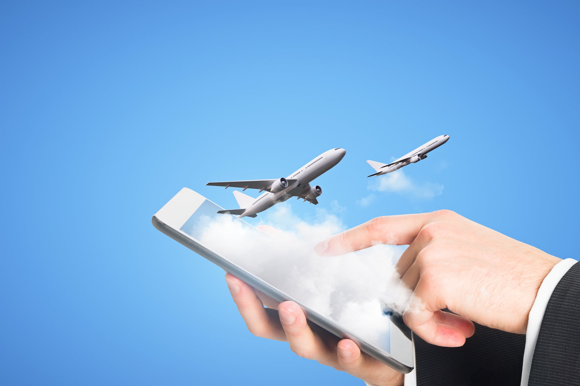 a person's hand using a smartphone while two airplanes fly out of the phone