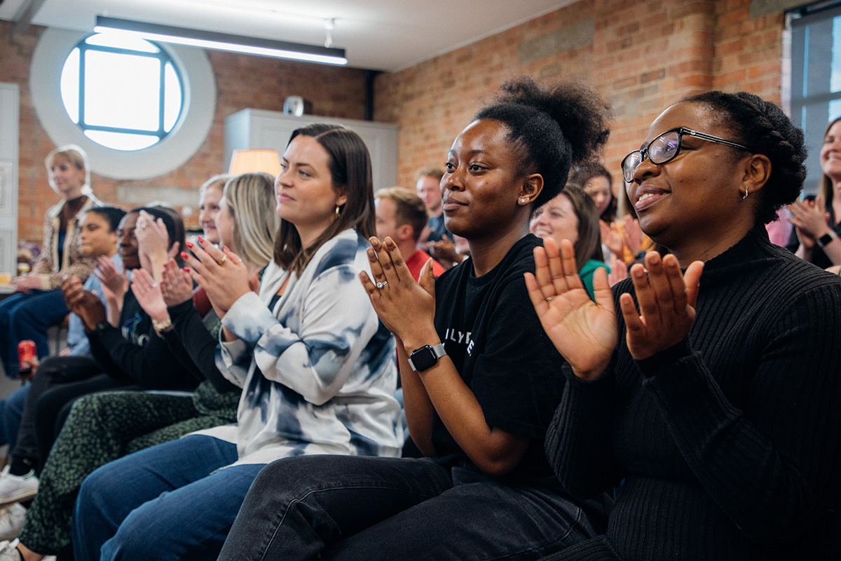 Papier team members applauding at a presentation