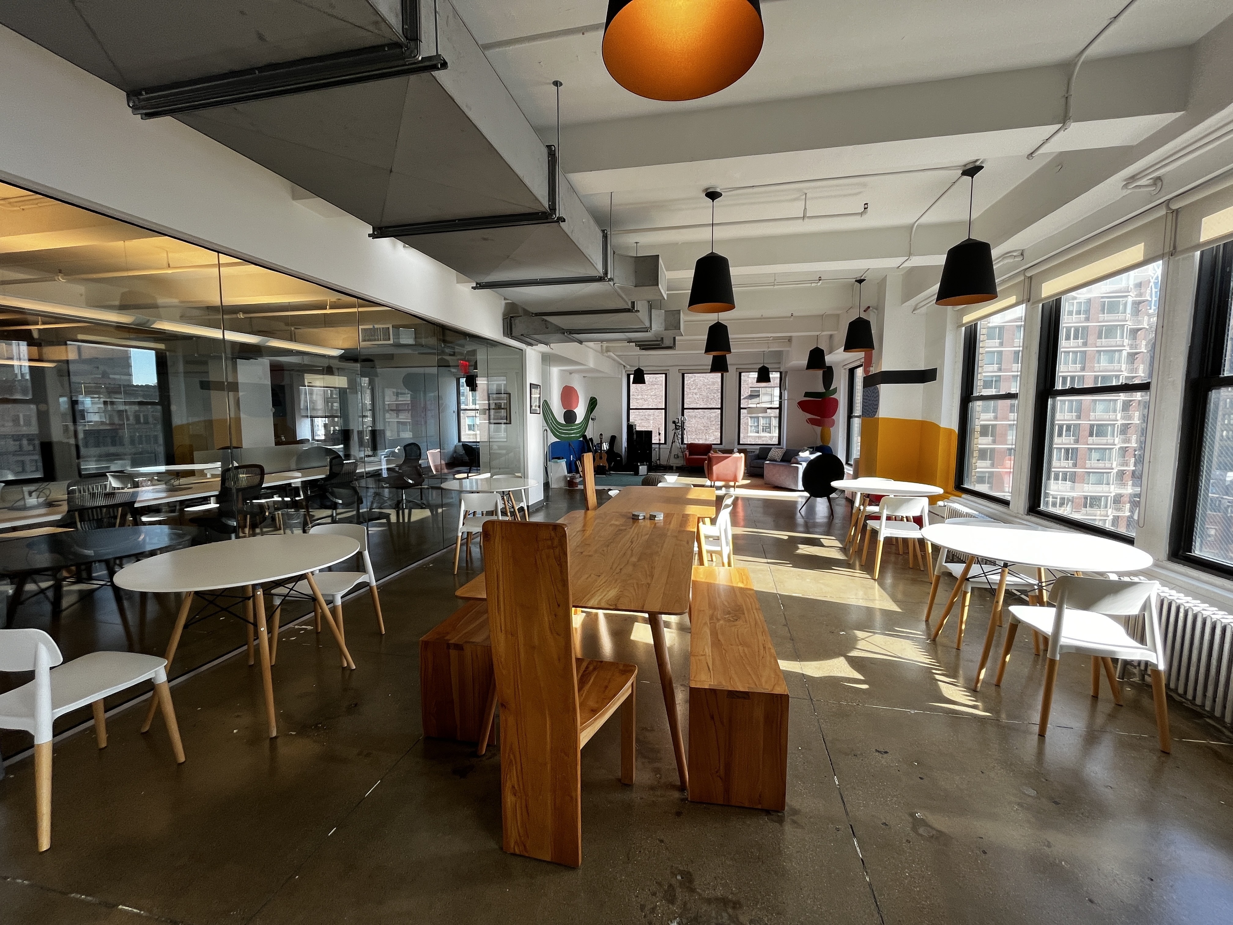  A photo of a sunny communal area in the Regal.io office, with tables and chairs.