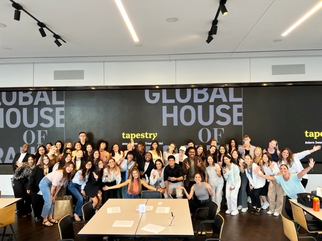 A group of Tapestry employees pose in the office.