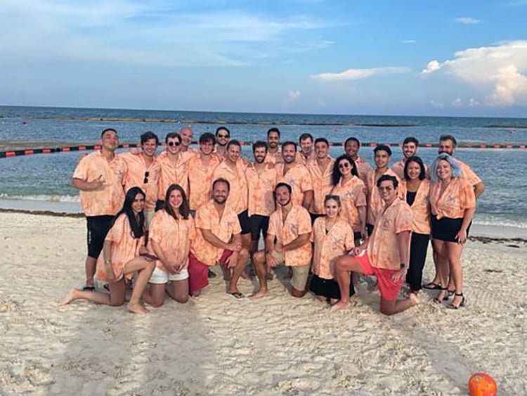 Tropic group photo on the beach with team members wearing Hawaiian shirts