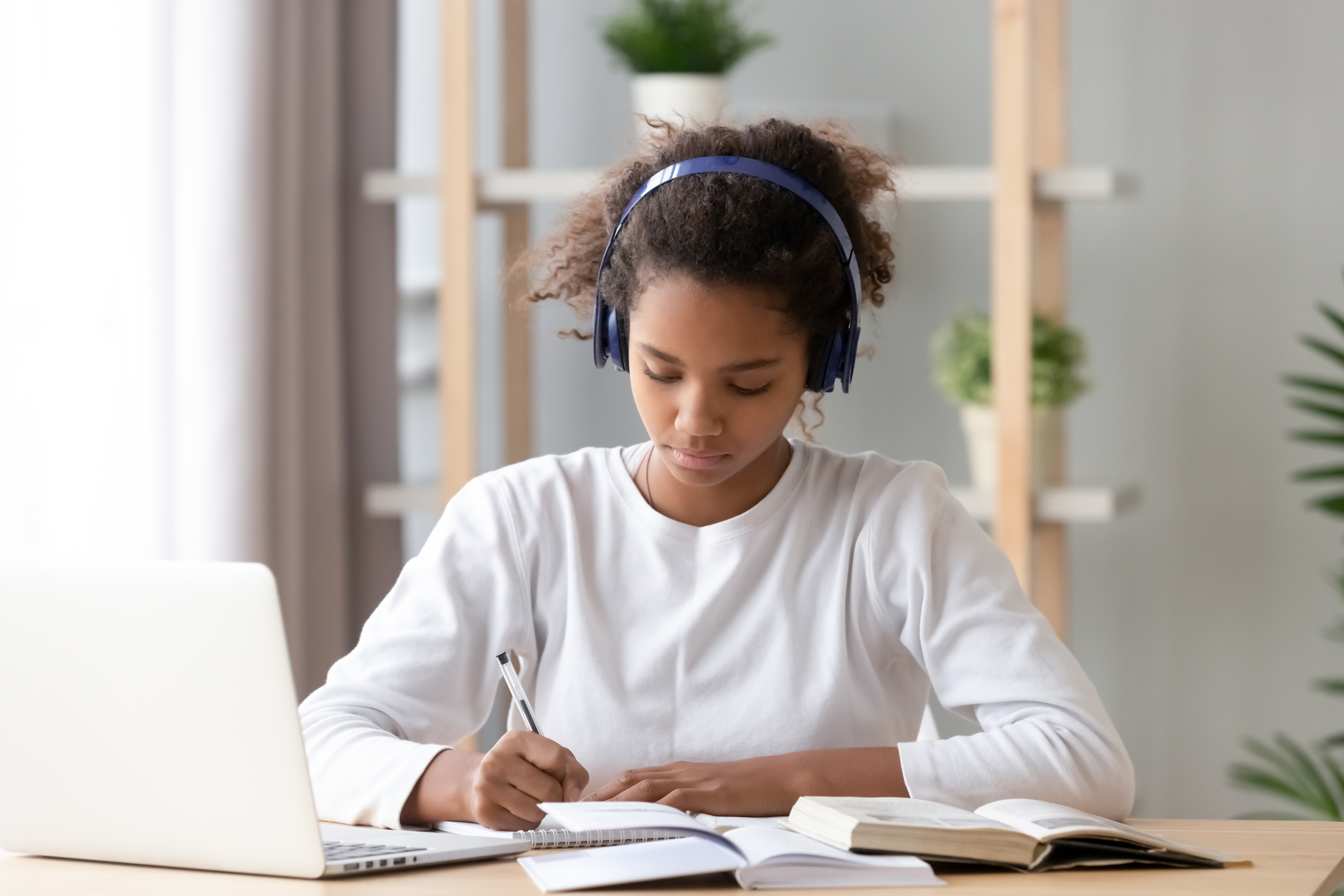 A student wearing headphones and using a laptop