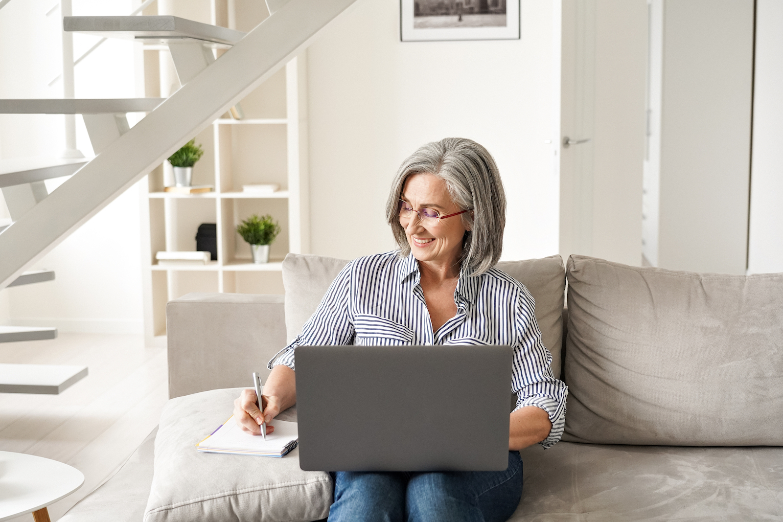 Woman sitting on a couch with a laptop resting on her lap