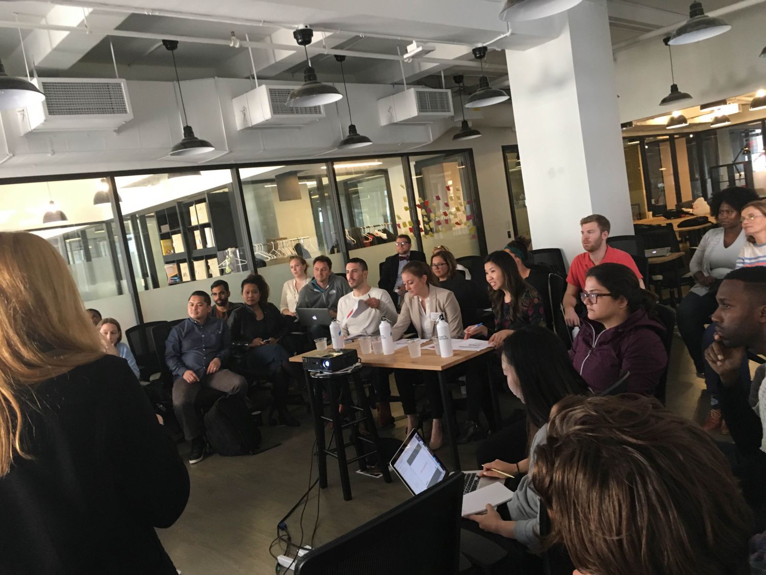 Judges look on as Startup Institute students deliver their three minute presentation.